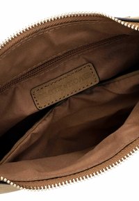 Pochette en tissu brun avec une fermeture éclair argentée, dotée d'un intérieur lisse et d'une petite poche zippée. Comprend une étiquette en cuir à l'intérieur.