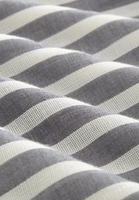 Tejido a rayas con franjas alternas de un grueso gris oscuro y blanco, con un tejido texturizado que crea una apariencia en capas y ondulada.