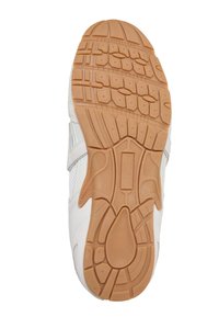 Semelle de chaussure avec une bande de roulement en caoutchouc beige présentant des motifs géométriques et texturés sur une basket blanche.