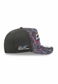Black cap with a multicolored splatter pattern. Features a flat brim, perforated panels, and a side patch reading "CRUCIAL CATCH INTERCEPT CANCER."