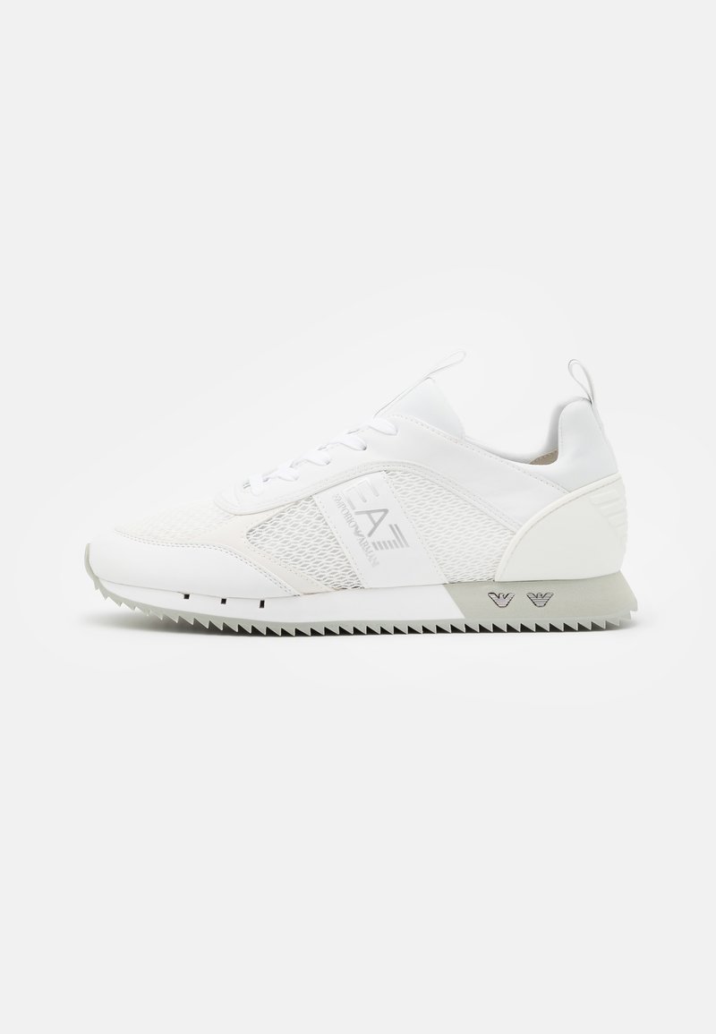 Białe sportowe sneakersy z siatkową cholewką, warstwową konstrukcją, wyściełanym kołnierzem oraz teksturowaną gumową podeszwą z wzorem w zygzak.