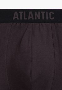 Ciemnoszare bokserki z elastycznym czarnym pasem, na którym znajduje się tekst "ATLANTIC" napisany dużymi literami. Gładka tekstura z lekki połyskiem.