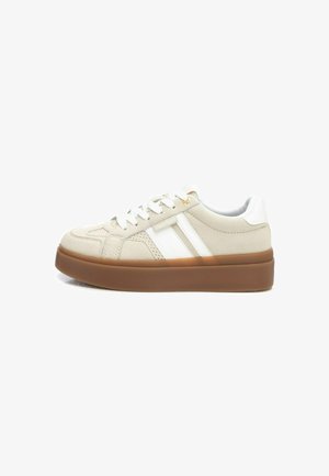 Sneakers beige con strisce bianche, caratterizzati da una parte superiore texturizzata, punta rotonda e una suola in gomma marrone chunky. Lacci dello stesso colore.
