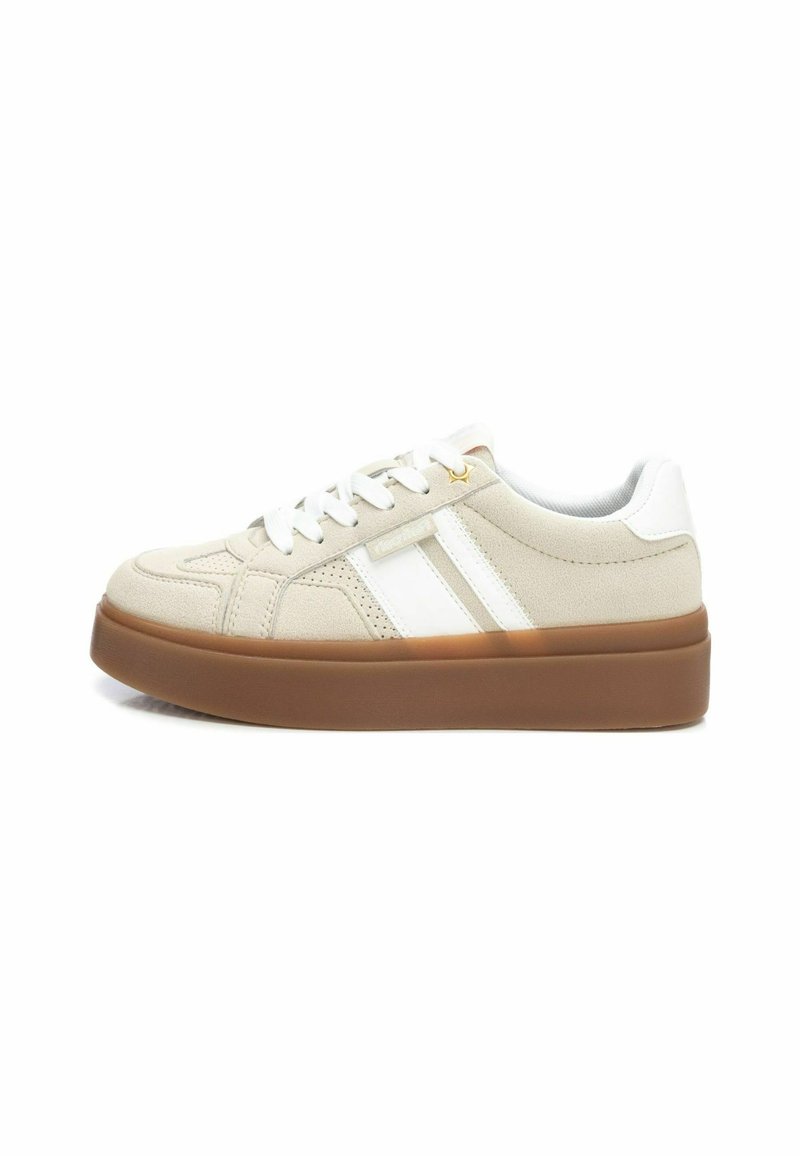 Zapatillas beige con rayas blancas, con un upper texturizado, puntera redonda y una suela de goma marrón gruesa. Cordonera en color a juego.
