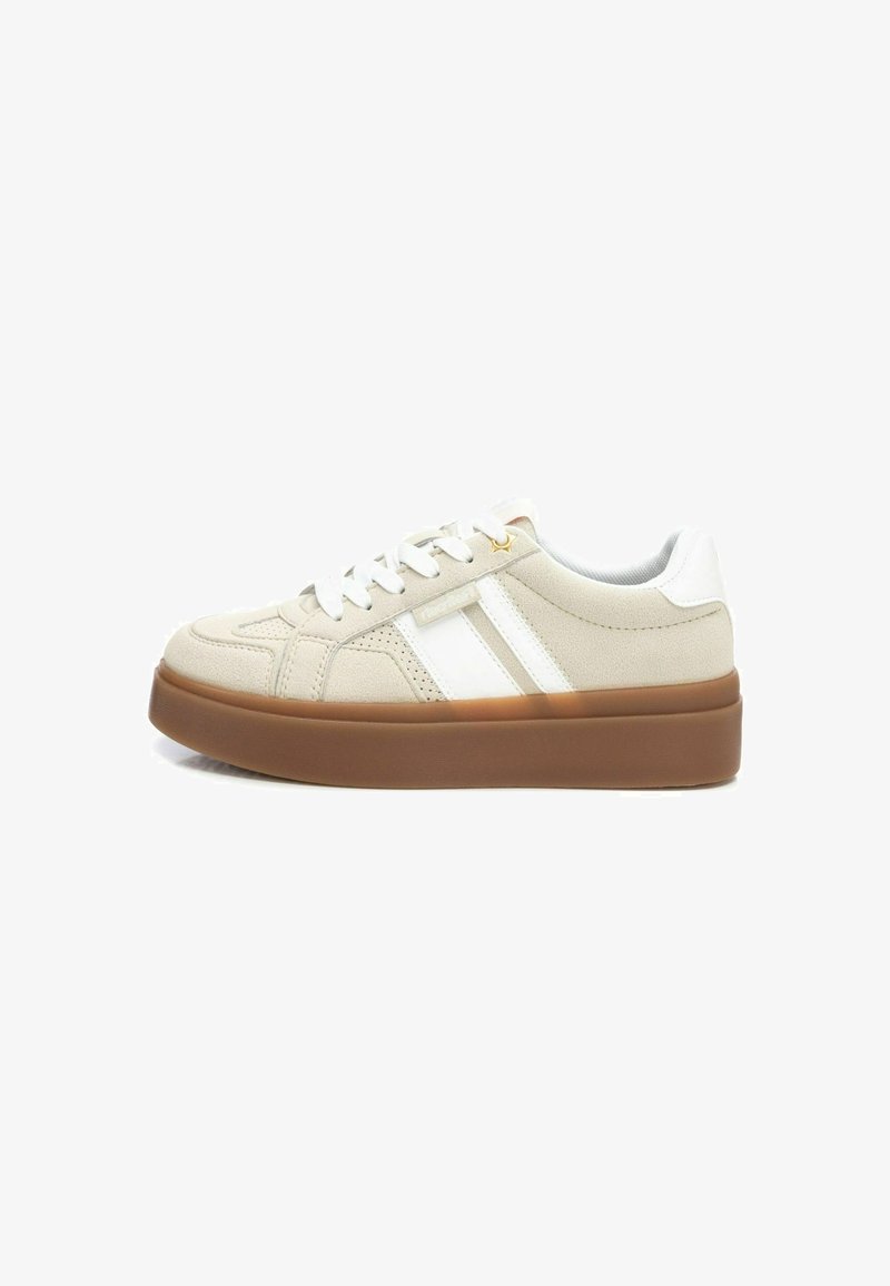 Zapatillas beige con rayas blancas, con un upper texturizado, puntera redonda y una suela de goma marrón gruesa. Cordonera en color a juego.
