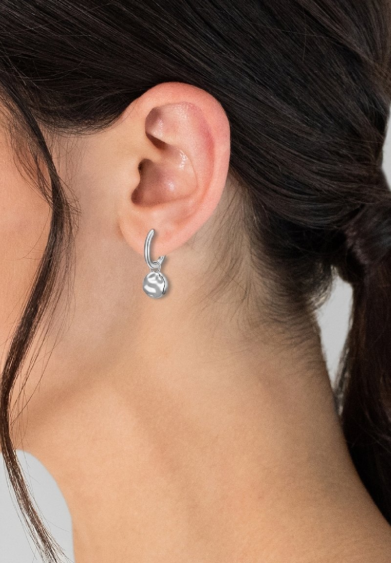 Srebrne obročeve uhane z majhnim, poliranim, okroglem obeskom, ki prikazuje gladko teksturo in odsevno površino.