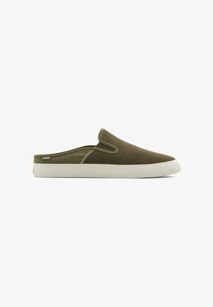 Olive green slip-on shoes with a soft, textured upper, white rubber sole, and contrasting stitching details along the side.