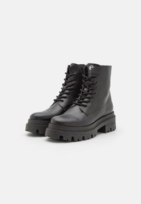 Black leather ankle boots featuring a sturdy platform sole, round toe, and classic lace-up design. Includes thick tread for traction.