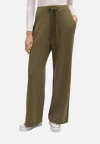 Pantalones de pierna ancha verde oliva hechos de una tela suave, con cintura elástica, bolsillos laterales y una textura suave.