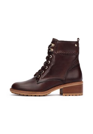 Brown leather ankle boot with a rounded toe, lace-up front, and a stacked heel. Features decorative stitching and gold-tone hardware.