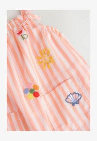 Rochie din țesătură rayată în piersică moale și alb, cu flori colorate brodate și o scoică, având bretele reglabile legate și buzunare.