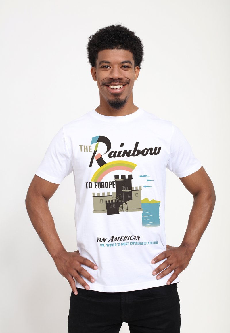 Vit bomullströja med en grafisk design av ett slott vid vattnet, med en regnbåge och texten "Regnbågen till Europa" i kraftfulla färger.