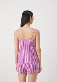 Randig tanktop och shorts-set i rosa och vitt. Tanktoppen har tunna axelband och en flödande design; shortsen har en lös passform.