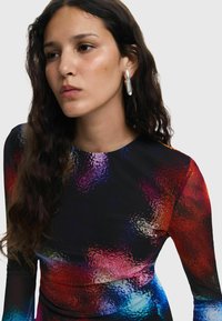 Rochie colorată cu mânecă lungă, prezentând un model abstract în nuanțe vibrante de roșu, albastru și mov. Confecționată dintr-un material neted și elastic.