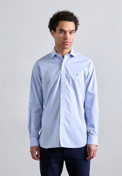 Camicia azzurro chiaro a quadri con maniche lunghe, colletto e un piccolo logo ricamato sul lato sinistro del petto. Tessuto dalla texture liscia.
