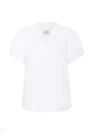 Blouse blanche à manches courtes avec encolure froncée et petite découpe en V, manches à revers pliés, et une étiquette "KAFFE" à l'intérieur du col.