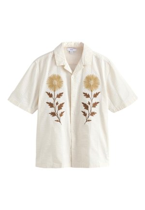 Flødefarvet kortærmet skjorte med knapper og krave, med symmetriske gyldengule og brune broderede blomsterdesigns på forstykkerne.