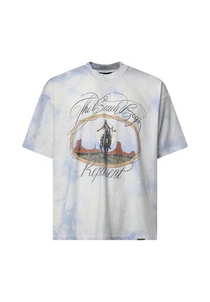Maglietta tie-dye bianca e azzurro chiaro con grafica di un cavaliere a cavallo e testo con scritto "The Beach Boys" e "Represent."