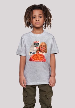Graues Baumwoll-T-Shirt mit einem Retro-Design von Kellogg’s Corn Flakes, das eine Frau mit einer Schüssel Müsli zeigt. Kurze Ärmel, entspannter Schnitt.
