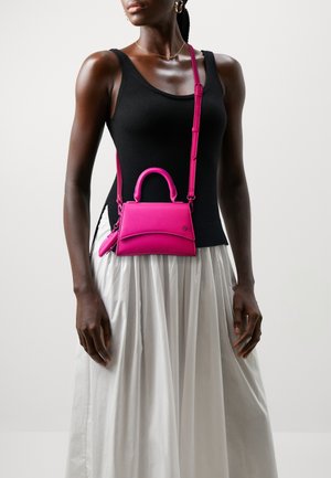 Strukturalna różowa skórzana torebka z górnym uchwytem i regulowanym paskiem na ramię. Projekt charakteryzuje się gładką fakturą i minimalistycznym stylem.