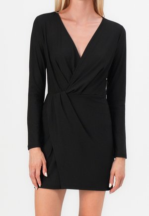 Czarna sukienka kopertowa z długimi rękawami, dekoltem w serek, marszczonym detalem w talii oraz lekko układającym się dołem. Wykonana z gładkiej, elastycznej tkaniny.