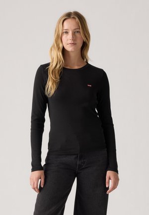 Black long-sleeve shirt made from soft fabric, featuring a round neckline and a small red logo on the left chest. Paired with dark pants.