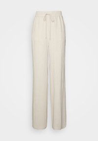 Beiga dragsko-byxor med elastisk midja, rak benstil och mjukt texturerat tyg, visade mot en enfärgad bakgrund.