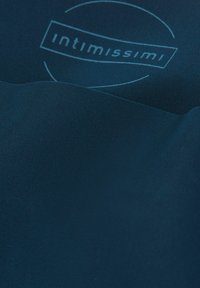 Granatowy materiał o gładkiej fakturze z subtelnym wzorem logo w jasnym niebieskim, umieszczonym w centrum okrągłego konturu.