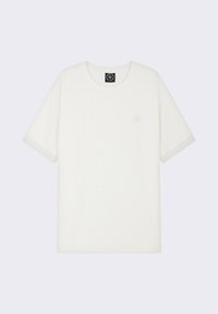 T-shirt en coton blanc avec un col rond, des manches courtes et une surface texturée ; il présente un logo brodé sur la poitrine.