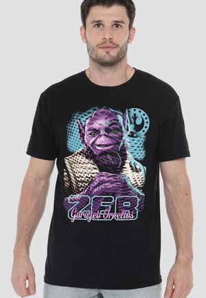 Man wearing black T-shirt with colorful graphic of purple alien character, text "Garazeb Orrelios," and Rebel Alliance symbol.