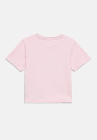 Κοντομάνικο μπλουζάκι από απαλό ροζ βαμβάκι. Κλασικός στρογγυλός λαιμός με ίσια τελείωμα. Λείο ύφασμα, μινιμαλιστικός σχεδιασμός, χωρίς γραφικά ή σχέδια.