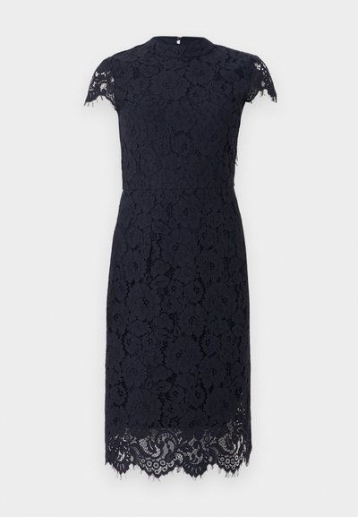 Brodasta mornarska haljina s kratkim rukavima, visokim ovratnikom i valovitim rubom. Izrađena od strukturirane čipkaste tkanine, prilagođena silueta.