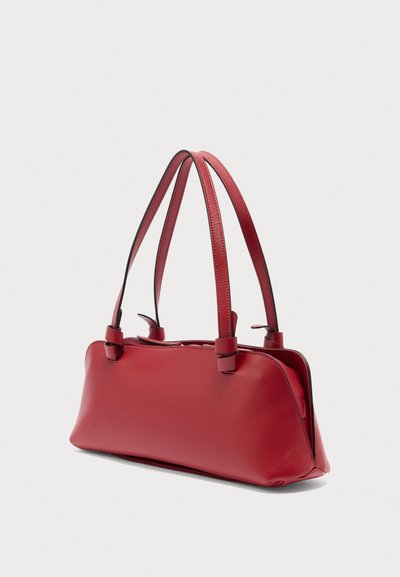 Sac à bandoulière en cuir rouge avec double sangle, forme rectangulaire et finition lisse, présenté sur un fond clair.