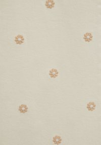 Tissu crème à surface texturée présentant des fleurs brodées éparses dans des tons pêche doux avec des centres blancs.