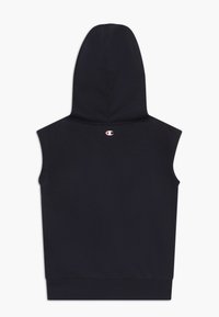 Ärmlös svart huva med en huva, tillverkad av mjukt tyg, med en liten logotyp i röd och vit på baksidan. Enkel, minimalistisk design.