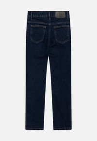 Jeans din denim de culoare albastră închisă cu un design drept. Caracteristici includ două buzunare la spate și un eticheta de marcă din piele pe talie.