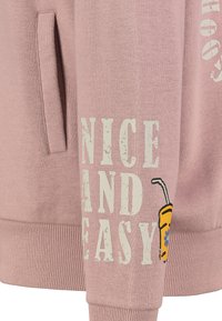 Lichtroze hoodie met een voorzak, geribde manchetten en de tekst "NICE AND EASY" in verouderd wit, met een grafisch drankje design op de mouw.