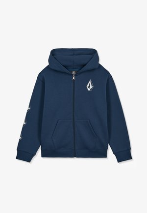 Sweat à capuche zippé bleu marine avec poches avant, une capuche, et des logos géométriques blancs sur la poitrine et la manche gauche.