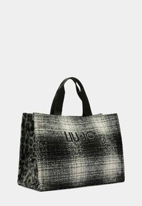 Sort og hvid ternet tote taske med struktureret stof, med et løveprint på siden, to sorte håndtag og prægede "LIU JO" logo.