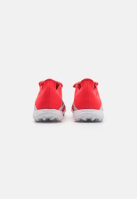 Red athletic shoes with a streamlined design, featuring a lightweight upper, cushioned white sole, and textured rubber outsole for traction.