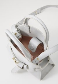 Borsa a mano in pelle grigia con forma strutturata, doppi manici superiori e hardware dorato. L'interno presenta una fodera rosa e una chiusura magnetica.