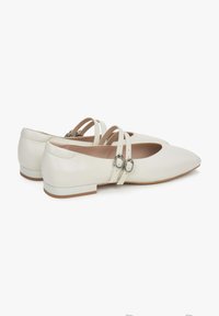 Białe skórzane baletki z lekkim noskiem, dwiema taśmami z metalowymi detalami w kolorze srebrnym i niskim blokowym obcasem. Gładka faktura.