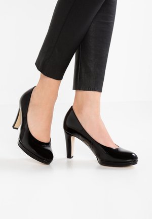 Schwarze lacklederne High Heels mit runder Spitze und mittelhohem Absatz. Das Design zeichnet sich durch eine glatte, schimmernde Oberfläche aus.