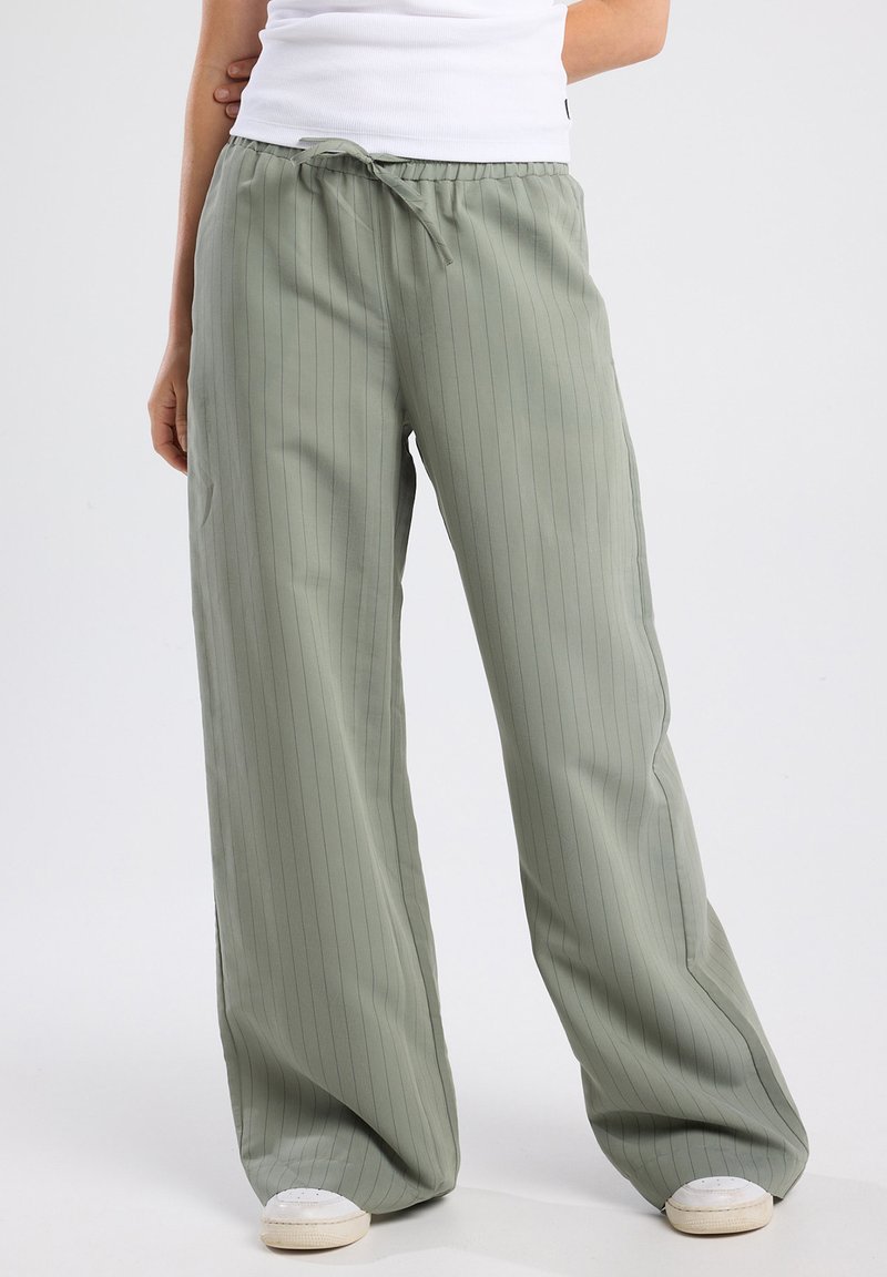 Light green wide-leg pants with vertical stripes, featuring an elastic waistband and drawstring. Made from a smooth, lightweight fabric.