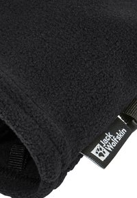 Coperta in pile nera con superficie texturizzata. Presenta un'etichetta tessuta con la scritta "Jack Wolfskin" e logo, e una cinghia nera attaccata.