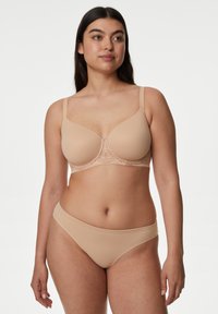 Sujetador beige acolchado con un borde de encaje en el centro, con tirantes ajustables y un acabado suave, combinado con braguitas sin costuras a juego.