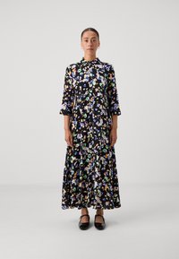 Lillelillekleit mustal taustal, millel on värvilised mustrid, nööbiga ees, krae ja kolmandikseelikud. Kandsin musti kingi.