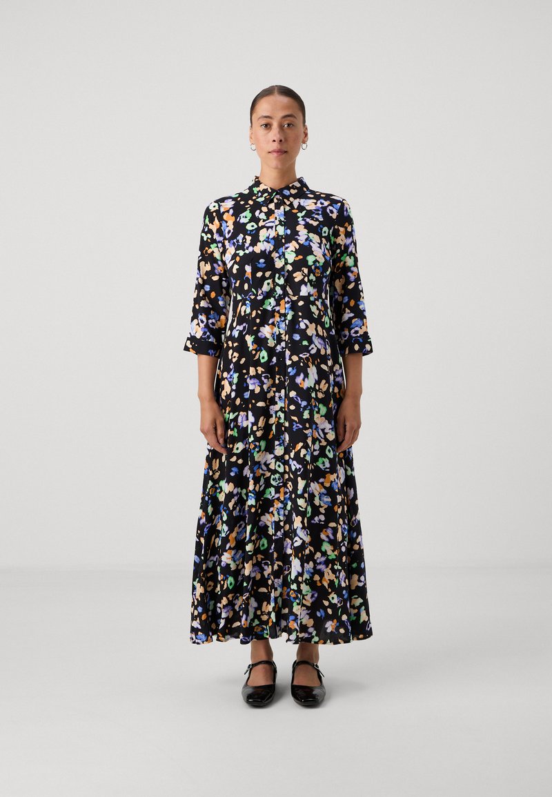 Lillelillekleit mustal taustal, millel on värvilised mustrid, nööbiga ees, krae ja kolmandikseelikud. Kandsin musti kingi.