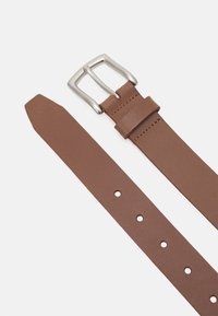 Brun läderbälte med en silverspänne, en slät yta och flera hål för justering. Ändan är avsmalnad för en elegant design.