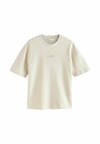 Camiseta de manga corta color beige claro, fabricada con un material suave. Presenta un sutil patrón a rayas y un pequeño logo impreso en el pecho.